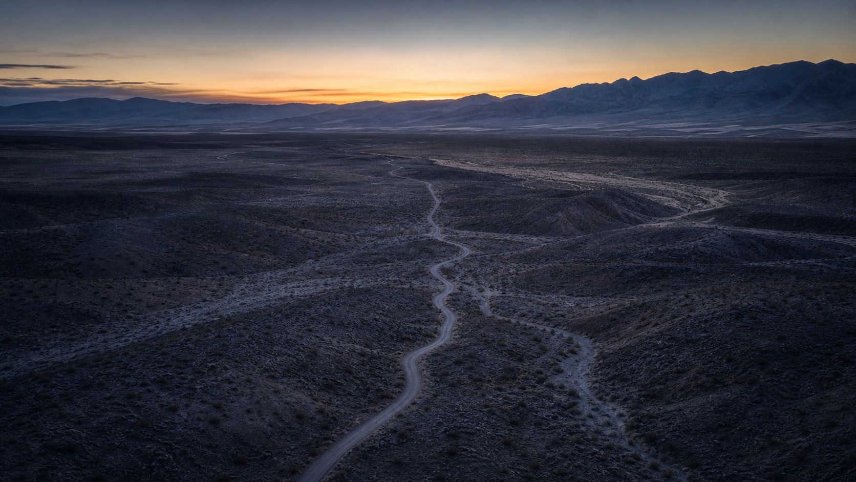 Aerial view of Nevada land and a winding access road at dawn